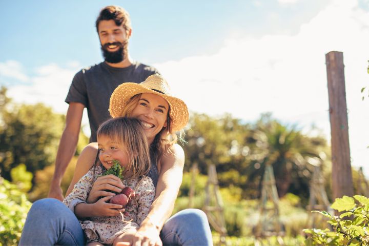 Joyful Parents With A Child Are Engaged In Farming Activities