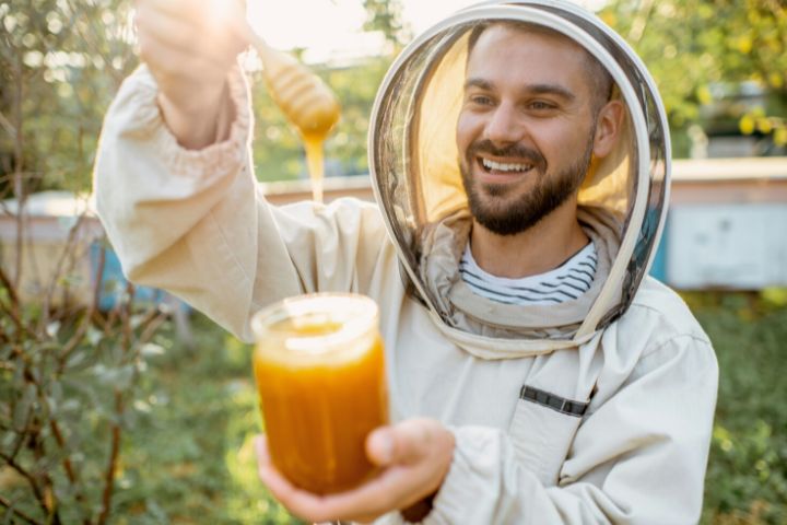 Beekeeper With Honey On The Apiary